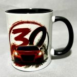 White mug with black interior/handle displaying a red sports car graphic and a bold red '30' brushstroke design on white ceramic.