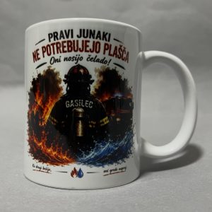 White ceramic mug featuring a fiery graphic with flames and smoke and partial red/black text around the top edge; photographed from the side on a gray surface.