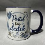 Close-up of a white ceramic mug with a dark blue rim and handle, decorated with blue hearts and cursive text.
