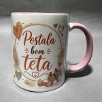 White mug with a pink handle, orange hearts, and red cursive text; coffee stains around the base on a gray surface.